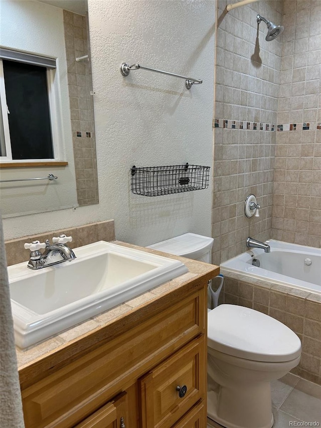 full bathroom featuring tile patterned flooring, vanity, toilet, and tiled shower / bath