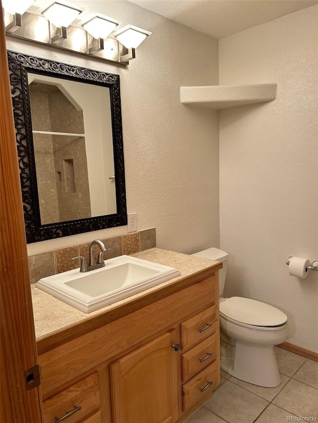 bathroom featuring toilet, vanity, and tile patterned floors