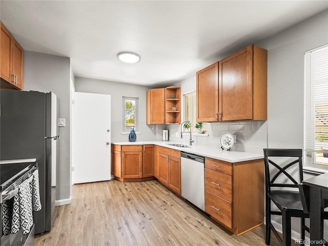 2695 S Logan St, Denver, CO 80210 - kitchen with appliances with stainless steel finishes, a sink, open shelves, light wood-type flooring, and decorative backsplash