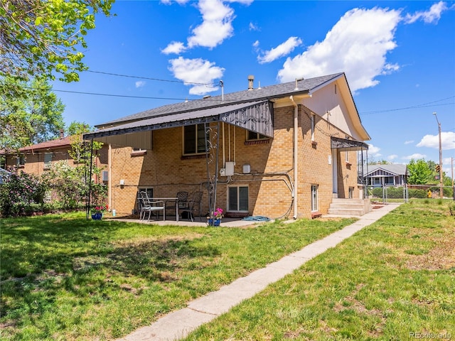 2695 S Logan St, Denver, CO 80210 - rear view of property featuring brick siding, a yard, and a patio