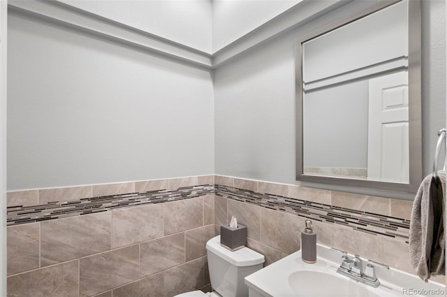 bathroom featuring vanity, tile walls, and toilet