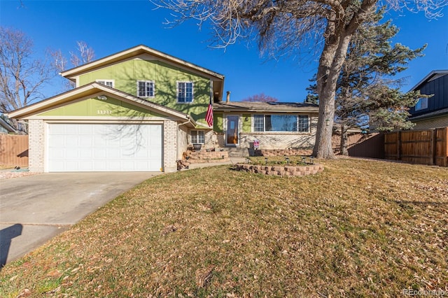 tri-level home featuring driveway, a front yard, fence, and brick siding