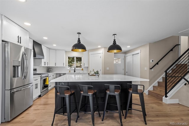 8334 Allison Ct, Arvada, CO 80005 - kitchen featuring appliances with stainless steel finishes, wall chimney exhaust hood, a kitchen breakfast bar, white cabinets, and recessed lighting