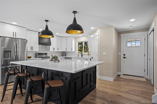 8334 Allison Ct, Arvada, CO 80005 - kitchen featuring stainless steel appliances, a sink, white cabinets, light countertops, and recessed lighting