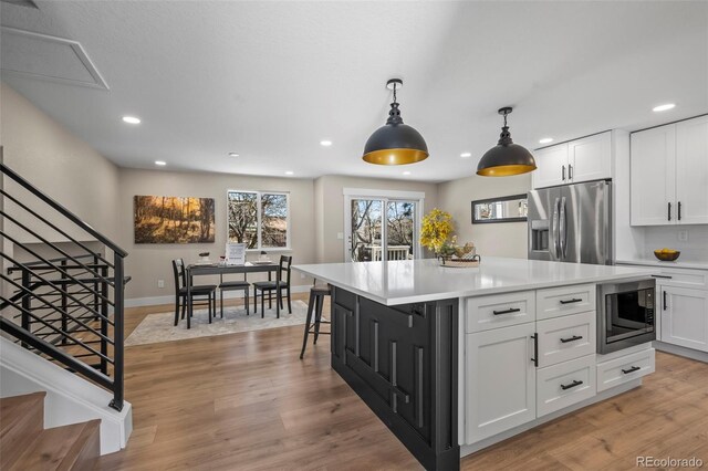 8334 Allison Ct, Arvada, CO 80005 - kitchen featuring stainless steel appliances, white cabinets, recessed lighting, light countertops, and hanging light fixtures