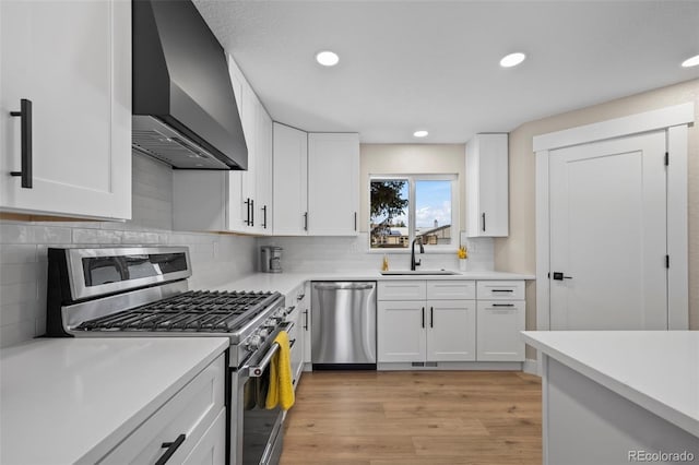 8334 Allison Ct, Arvada, CO 80005 - kitchen with appliances with stainless steel finishes, wall chimney exhaust hood, a sink, light countertops, and recessed lighting