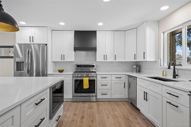 8334 Allison Ct, Arvada, CO 80005 - kitchen with appliances with stainless steel finishes, a sink, wall chimney range hood, light countertops, and white cabinets