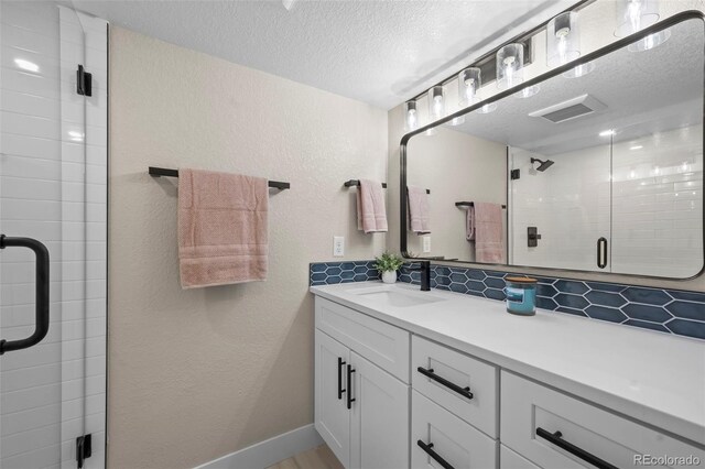 8334 Allison Ct, Arvada, CO 80005 - full bath with a textured ceiling, vanity, a stall shower, a textured wall, and decorative backsplash
