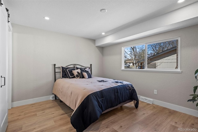 8334 Allison Ct, Arvada, CO 80005 - bedroom featuring recessed lighting, wood finished floors, baseboards, and a barn door