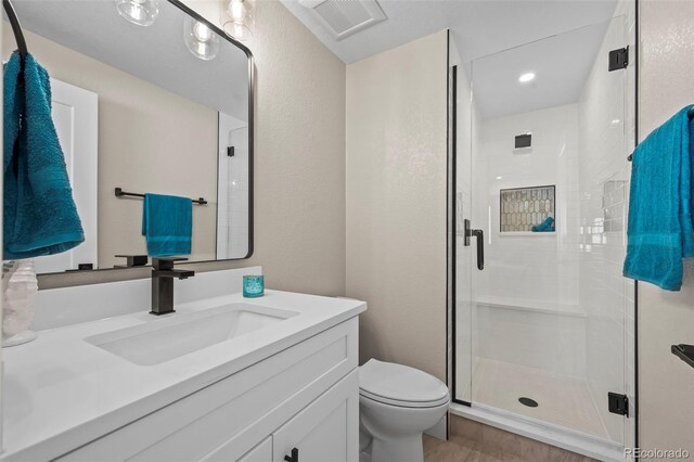 8334 Allison Ct, Arvada, CO 80005 - bathroom featuring vanity, toilet, a shower stall, wood finished floors, and recessed lighting