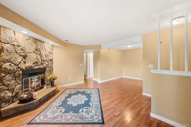 living room featuring a fireplace, hardwood / wood-style floors, and a textured ceiling