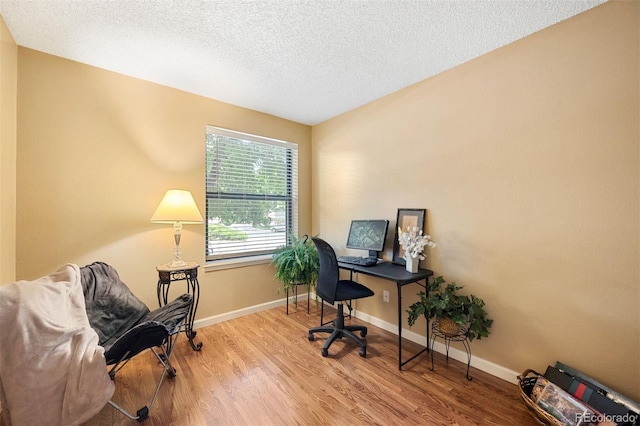 office with a textured ceiling and light wood-type flooring