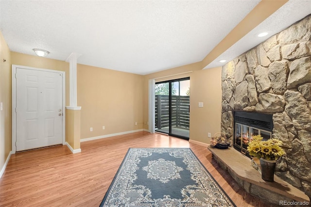 living room with a fireplace, light hardwood / wood-style floors, and a textured ceiling