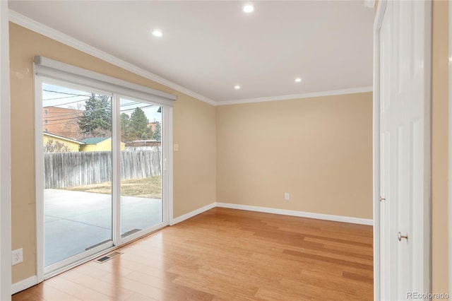 unfurnished room with light wood-type flooring, baseboards, visible vents, and ornamental molding