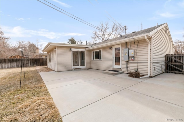 rear view of house with a patio, a lawn, and fence