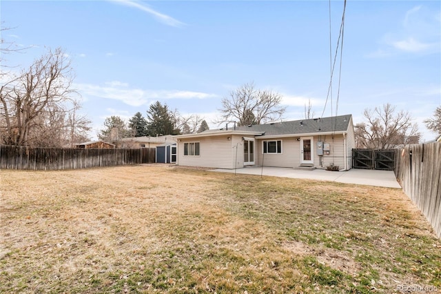 rear view of house with a patio area, a gate, a yard, and a fenced backyard