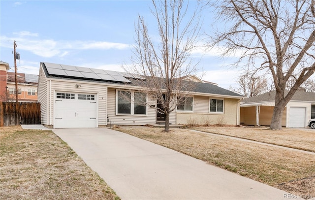 single story home with brick siding, solar panels, fence, concrete driveway, and a garage