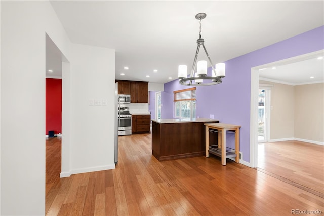 kitchen with light wood finished floors, baseboards, light countertops, a peninsula, and stainless steel appliances