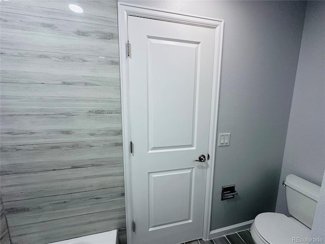 bathroom featuring baseboards and toilet