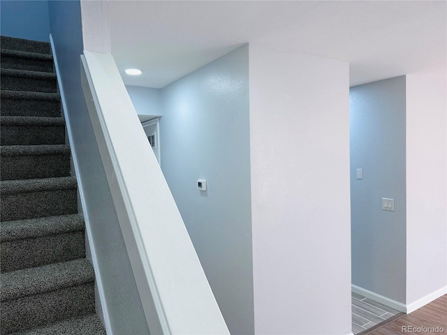 stairway featuring baseboards and wood finished floors