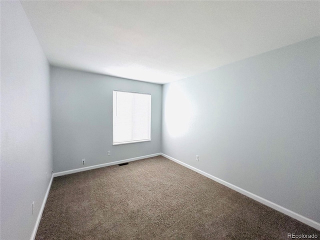 spare room featuring visible vents, carpet, and baseboards