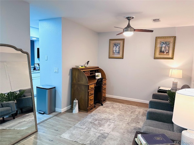 living room with ceiling fan, baseboards, wood finished floors, and visible vents