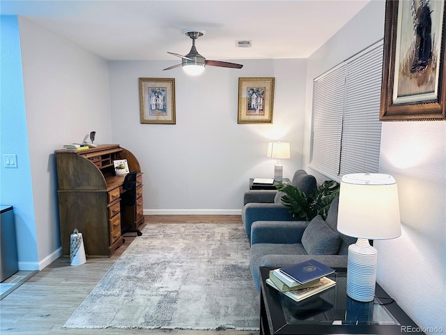 sitting room featuring light wood-type flooring, visible vents, a ceiling fan, and baseboards