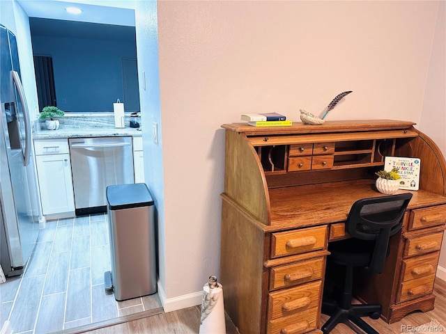 home office featuring light wood finished floors and baseboards