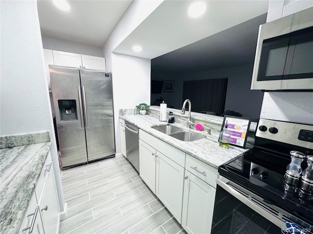 kitchen with white cabinets, appliances with stainless steel finishes, recessed lighting, and a sink