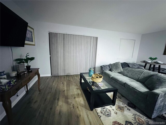 living area with baseboards and wood finished floors