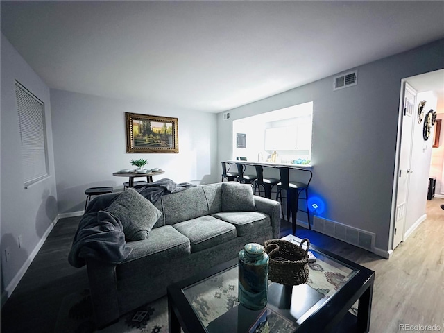 living room with baseboards, wood finished floors, and visible vents