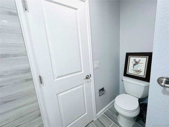 bathroom with toilet and baseboards