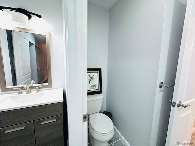 bathroom featuring baseboards, toilet, and vanity