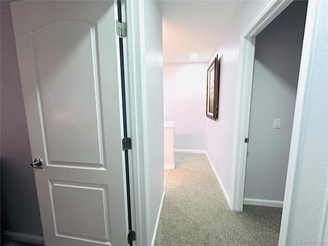 hall with baseboards and carpet flooring