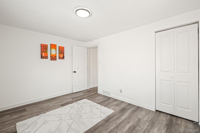 unfurnished bedroom featuring hardwood / wood-style floors and a closet