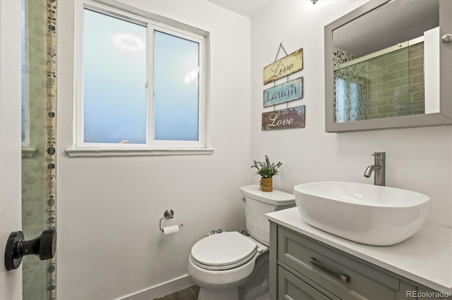 bathroom with vanity, toilet, and a shower