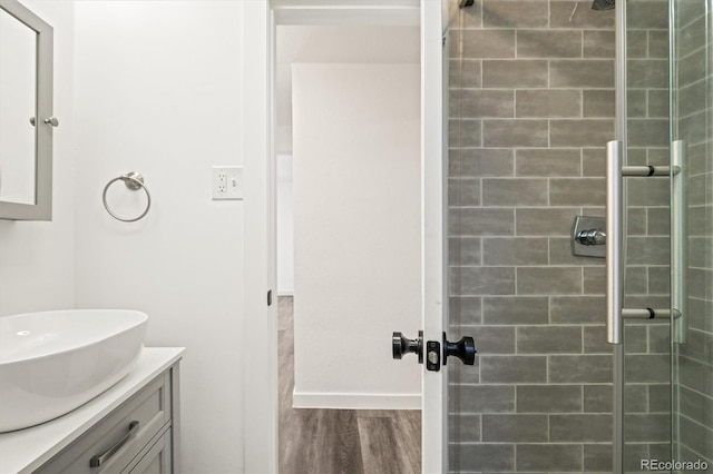 bathroom featuring vanity, tiled shower, and hardwood / wood-style floors