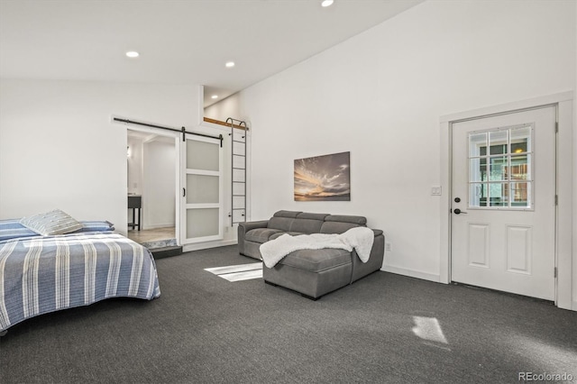 bedroom with high vaulted ceiling, a barn door, and dark carpet