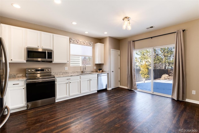 kitchen featuring sink, dark wood-type flooring, white cabinets, and appliances with stainless steel finishes