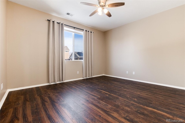 spare room with dark wood-type flooring and ceiling fan