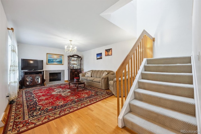 1254 S Yosemite Way Unit 99, Denver, CO 80247 - living area with wood finished floors, stairs, a chandelier, and a fireplace with raised hearth