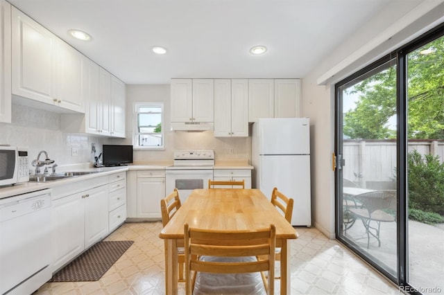 1254 S Yosemite Way Unit 99, Denver, CO 80247 - kitchen featuring white appliances, light floors, under cabinet range hood, a sink, and white cabinetry