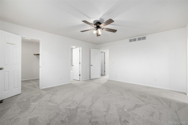 unfurnished bedroom featuring visible vents, carpet floors, baseboards, a spacious closet, and ensuite bath