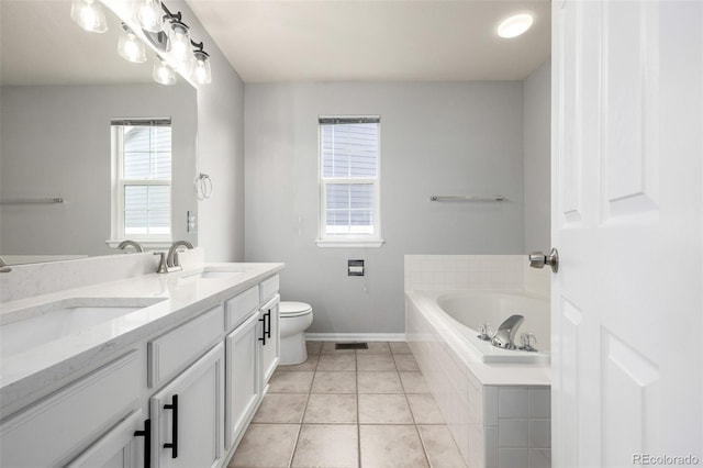 bathroom featuring a sink, tile patterned flooring, double vanity, baseboards, and a garden tub