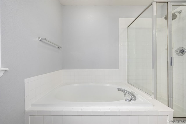 bathroom with a shower stall and a garden tub