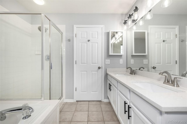 bathroom featuring a sink, tile patterned flooring, a shower stall, and double vanity