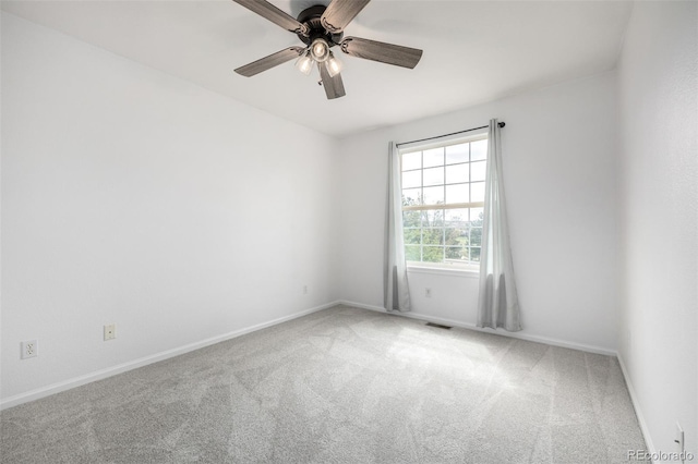 carpeted spare room with ceiling fan, visible vents, and baseboards