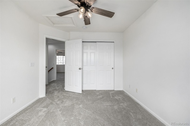 unfurnished bedroom with ceiling fan, attic access, baseboards, a closet, and carpet