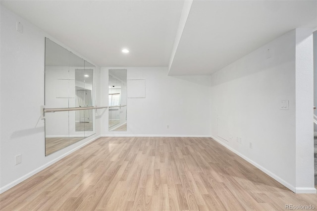 spare room with baseboards, recessed lighting, and wood finished floors