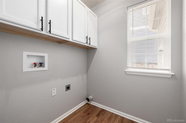 washroom with washer hookup, hookup for an electric dryer, dark wood finished floors, cabinet space, and baseboards